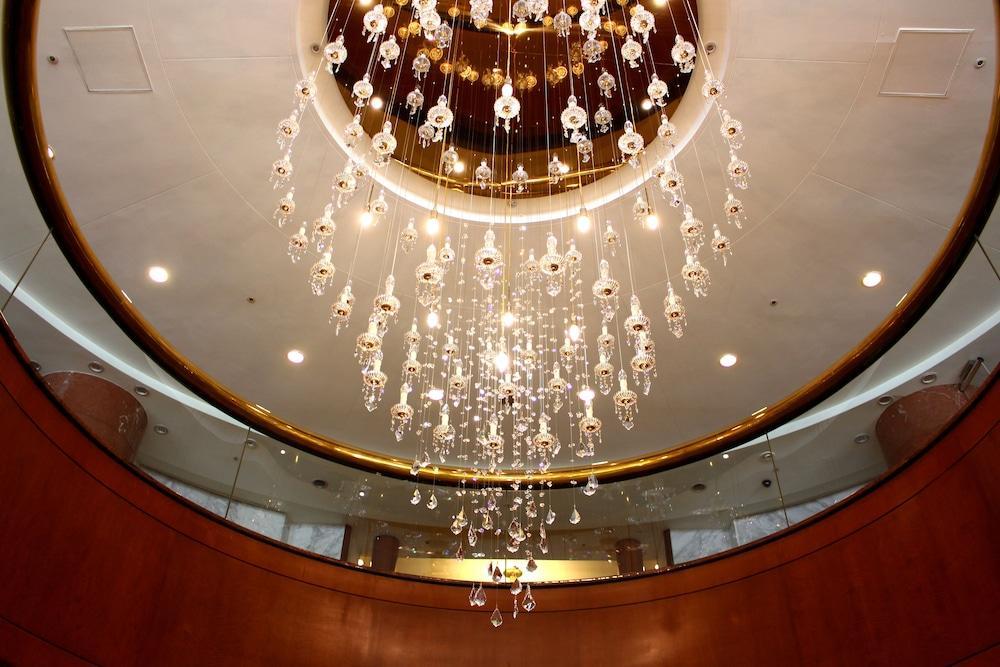 Evergreen Laurel Hotel - Taichung Bagian luar foto The photo shows an elegant chandelier hanging from a ceiling. The chandelier features numerous hanging crystals that reflect light, creating a sparkling effect. The ceiling itself is circular and designed with a smooth surface, accented by a circular