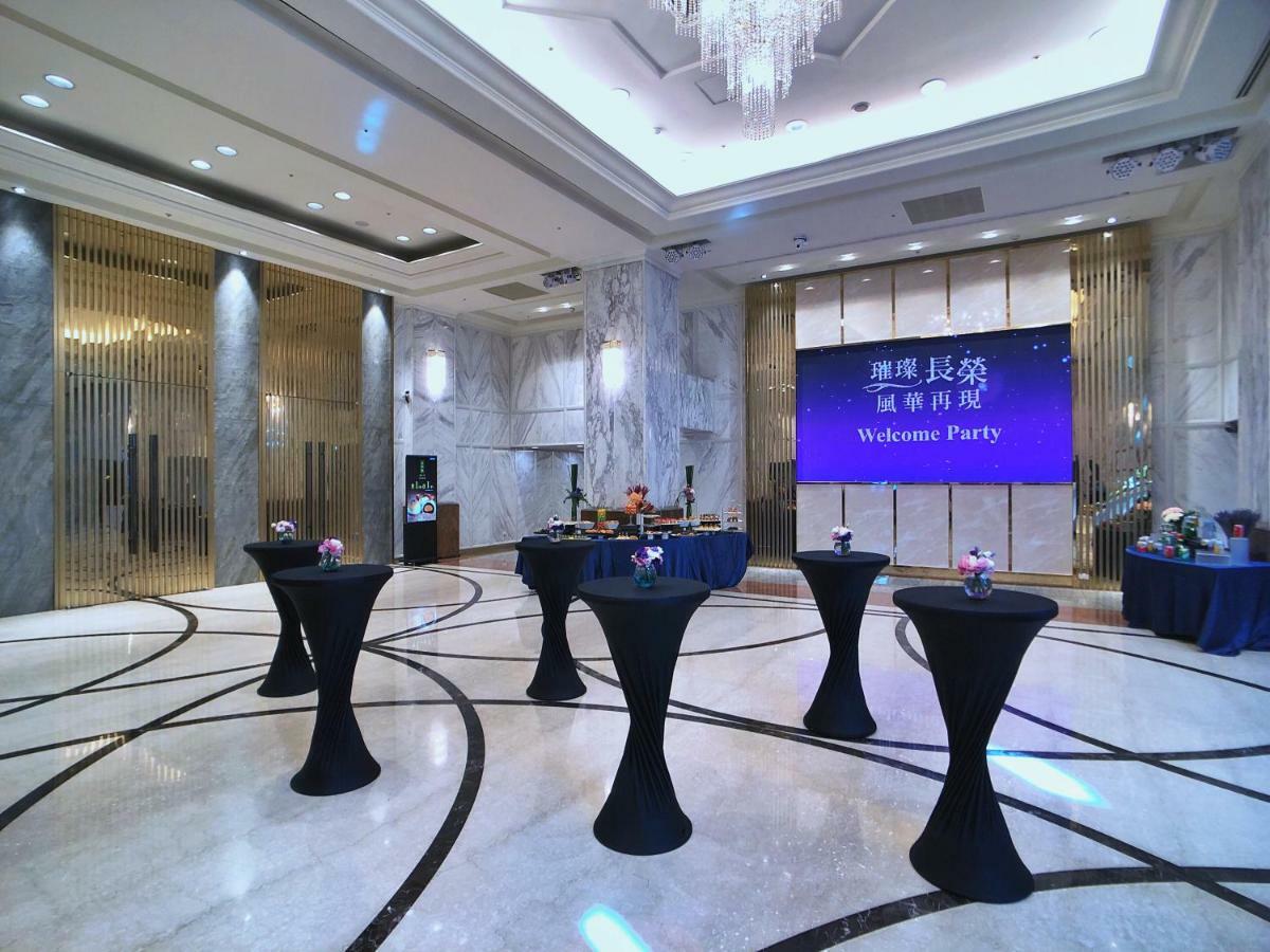 Evergreen Laurel Hotel - Taichung Bagian luar foto The photo depicts a spacious and elegantly decorated event space, likely set up for a welcome party. The room features polished marble flooring and tall ceilings, giving it a sophisticated atmosphere. In the center, several round tables with black ta