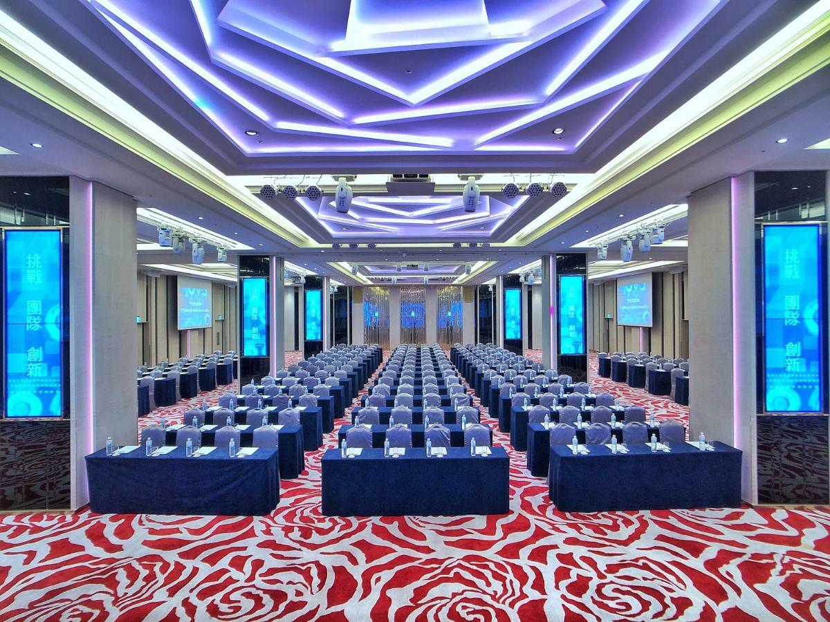 Evergreen Laurel Hotel - Taichung Bagian luar foto The photo shows a large conference or seminar room set up for an event. The space features rows of tables and chairs arranged neatly, likely for attendees to participate in discussions or presentations. The room is well-lit with modern, colorful ligh