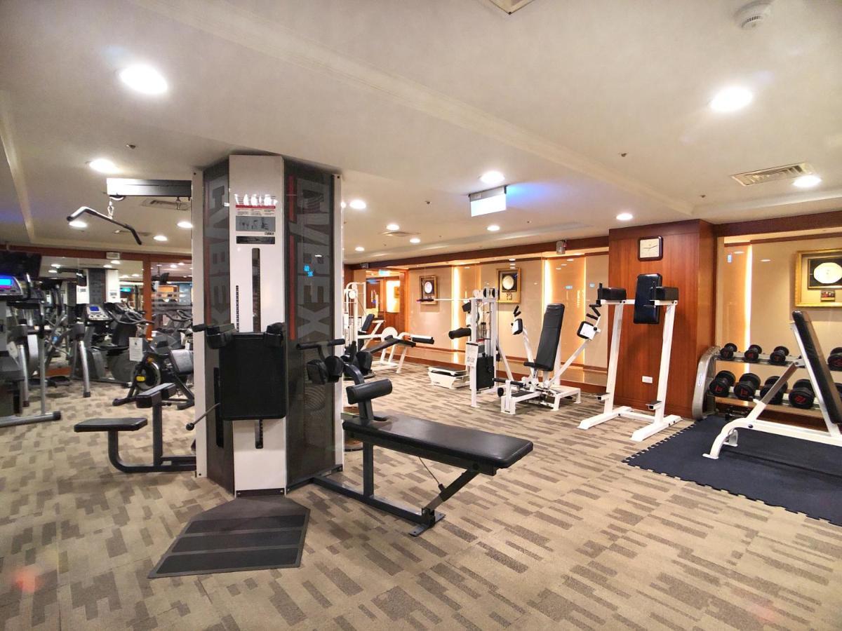 Evergreen Laurel Hotel - Taichung Bagian luar foto The photo shows an indoor gym or fitness area. It features various workout equipment, including:

- A multi-station gym machine in the center for strength training.
- Weight benches and free weights organized on shelves.
- Cardio equipment, likely tr